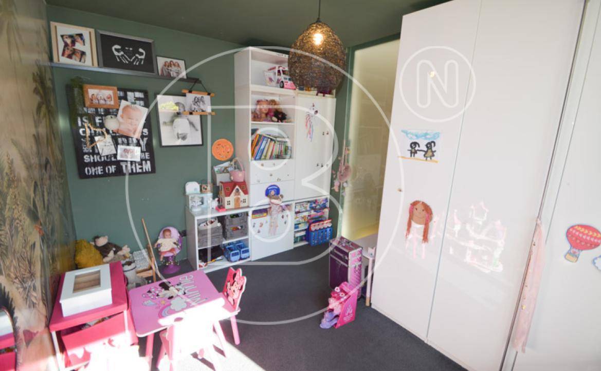 Freundliches Kinderzimmer mit Stauraum, Spielzeug und kreativer Wandgestaltung.