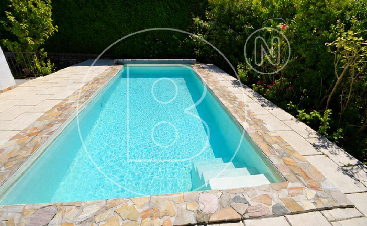 Nahaufnahme des Pools mit hellblauem Wasser und dekorativer Steineinfassung.