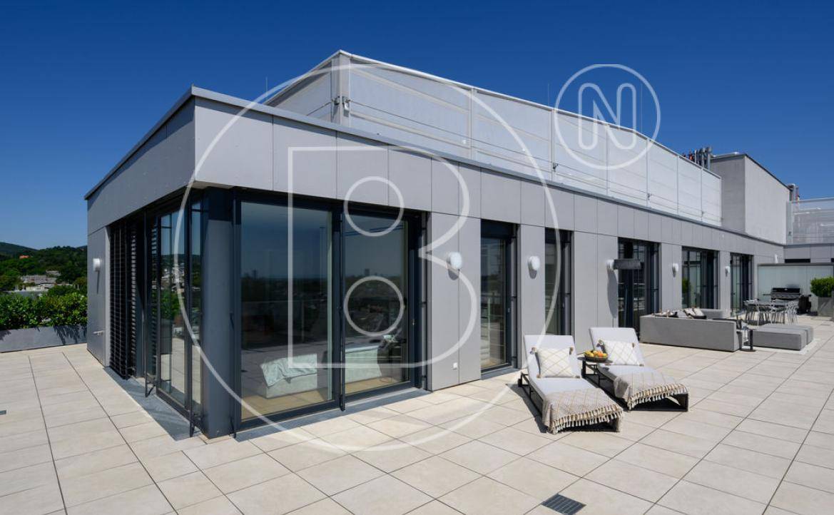 Weitläufige Dachterrasse mit modernen Fliesen und Sonnenliegen, ideal zum Entspannen.