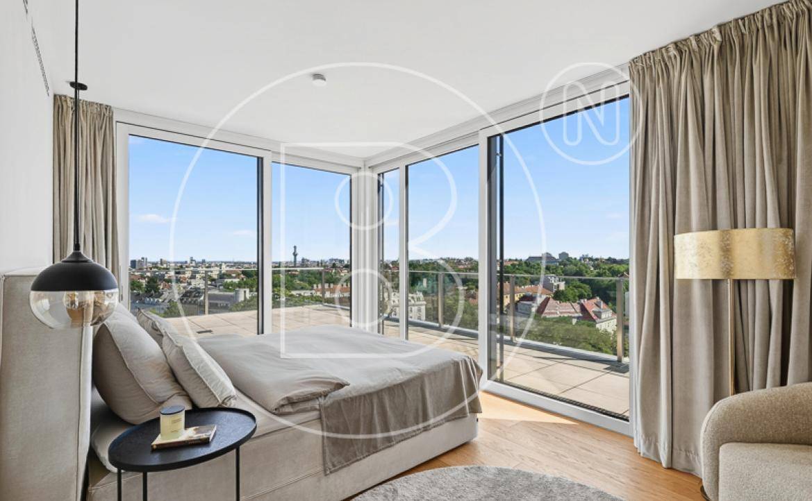 Schlafzimmer mit großem Bett und raumhohen Fenstern, die einen weiten Stadtblick ermöglichen.