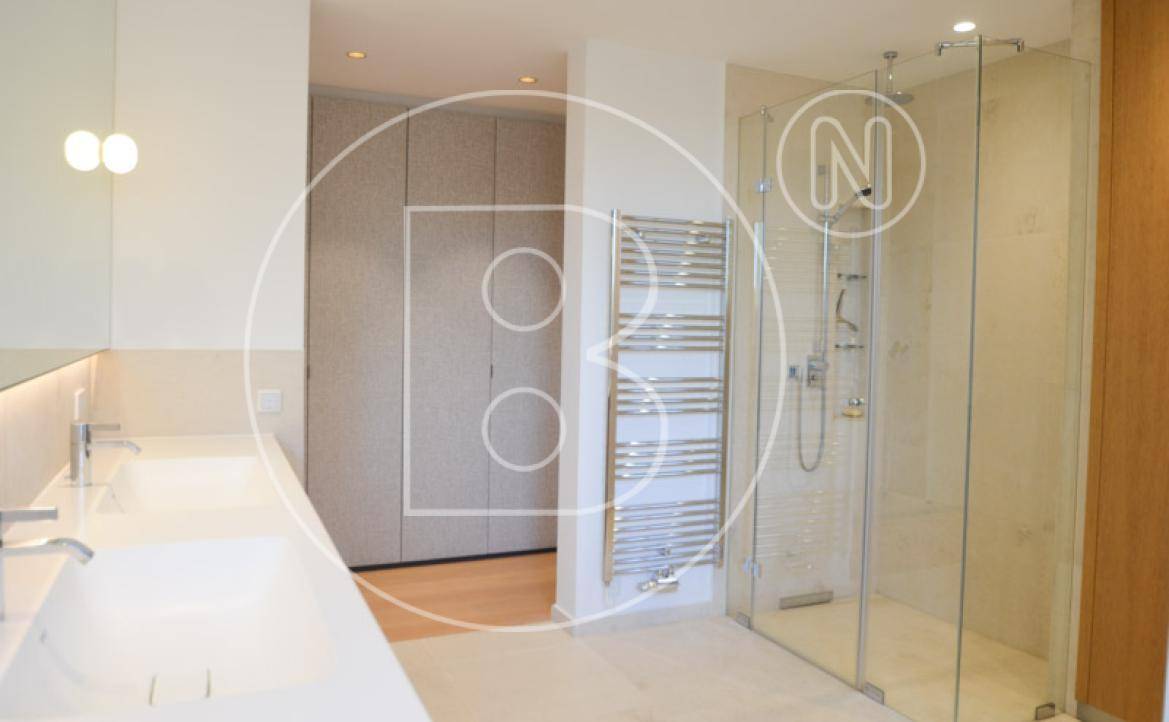 Elegantes Badezimmer mit Doppelwaschbecken, begehbarer Dusche und beheiztem Handtuchhalter.