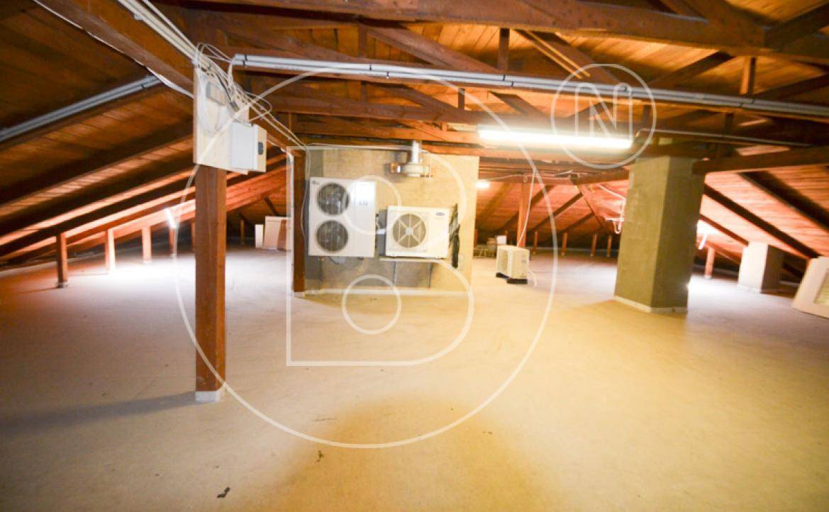 Geräumiger Dachboden mit sichtbaren Holzbalken und technischen Installationen.