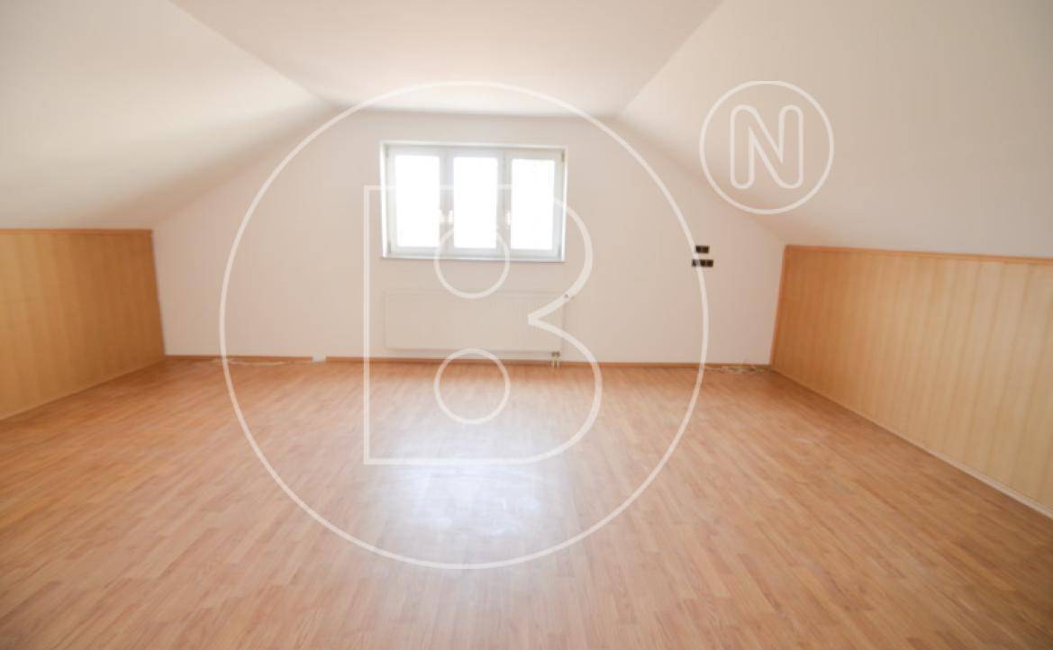 Heller Dachbodenraum mit Laminatboden und Dachschrägen, ideal für Ausbauzwecke.