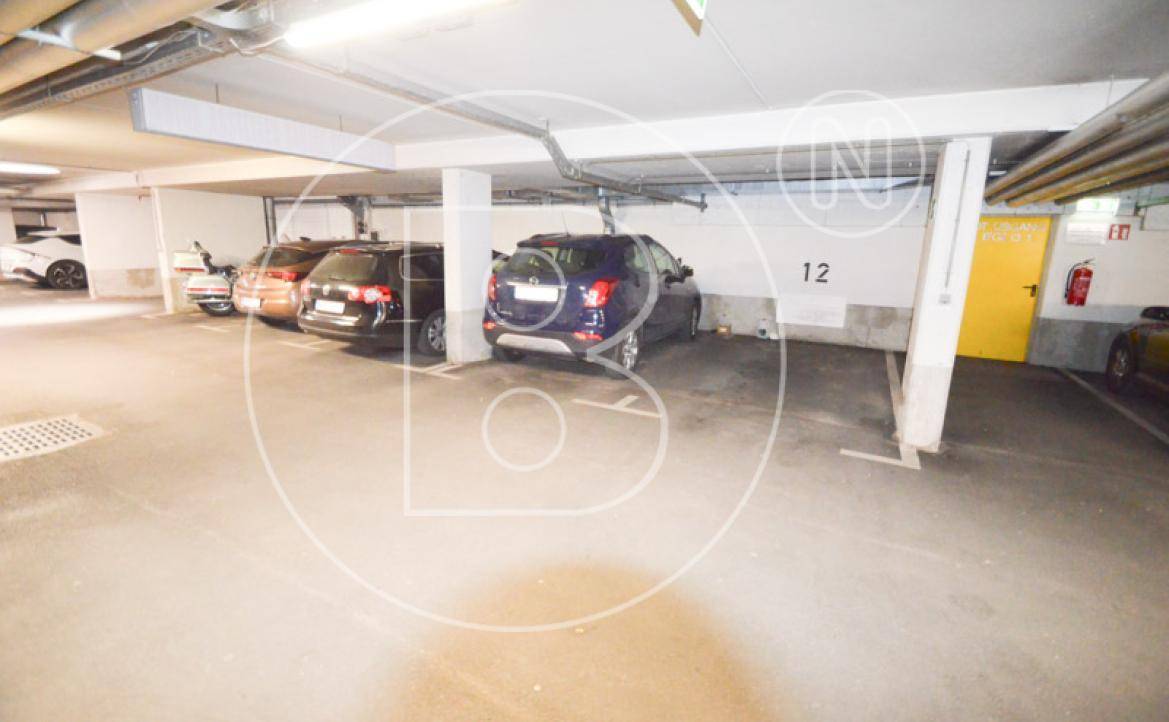 Geräumige Tiefgarage mit mehreren Stellplätzen und Betonstützen für Fahrzeuge.