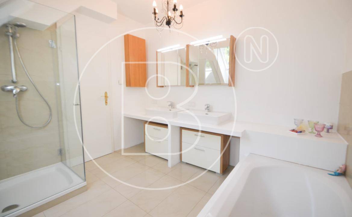 Modernes Badezimmer mit großer Duschkabine, Doppelwaschbecken und Badewanne.