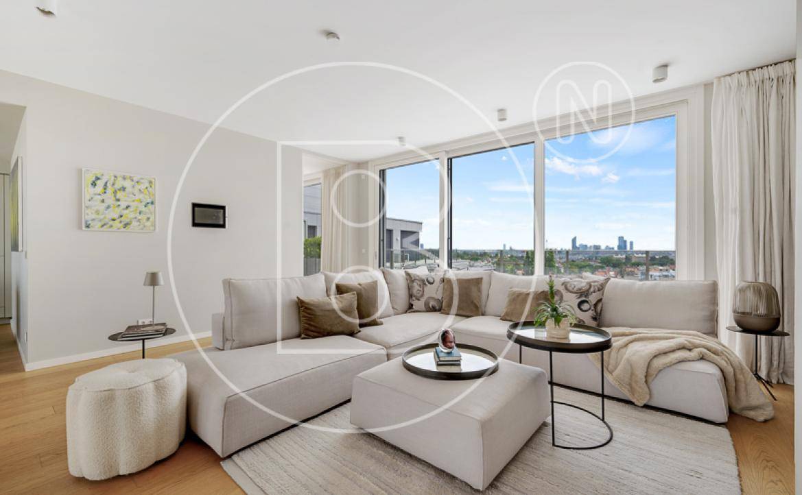 Geräumiges Wohnzimmer mit großem Sofa, Holzboden und Panoramafenstern mit Stadtblick.