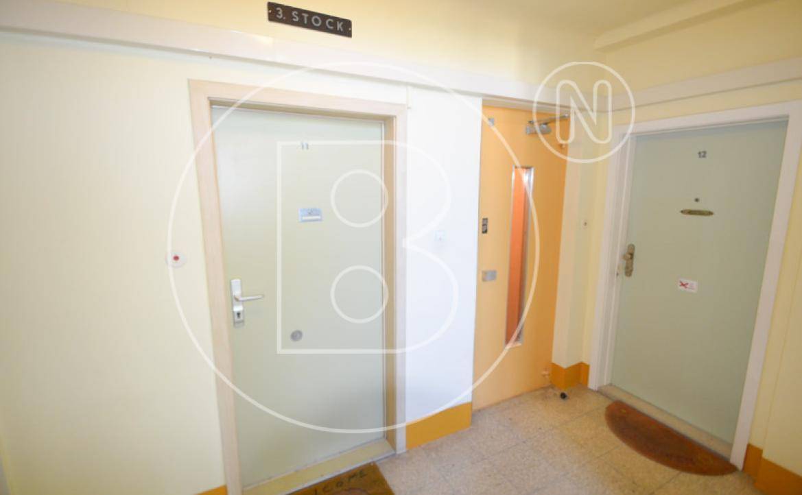 Flur im Gebäude mit mehreren Wohnungstüren und der Beschriftung "3. Stock" an der Wand.