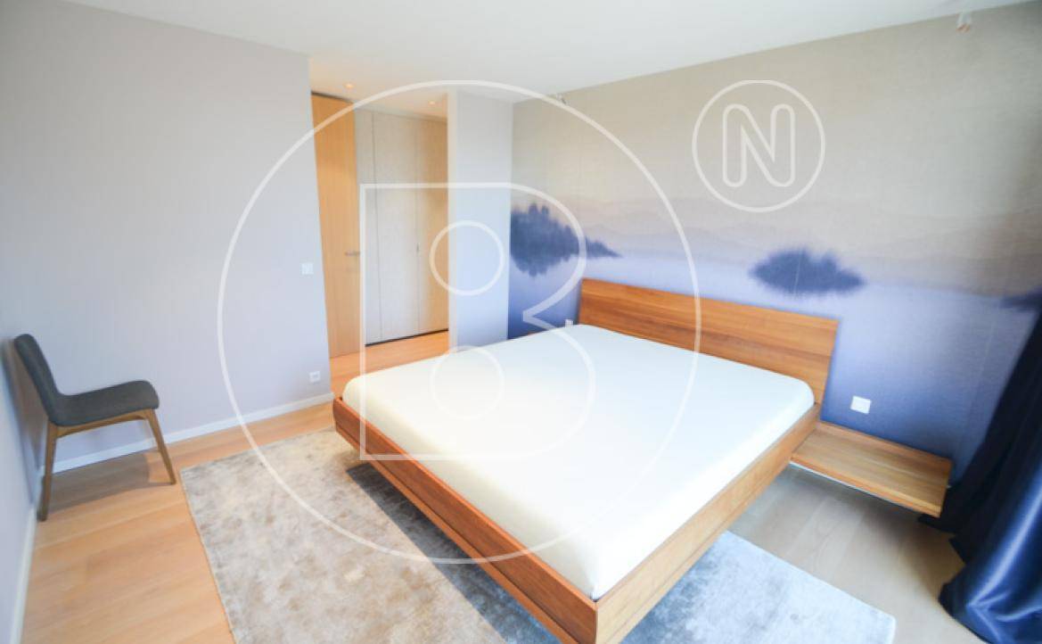 Modernes Schlafzimmer mit Holzbett, Nachttisch und dekorativer Wandgestaltung.