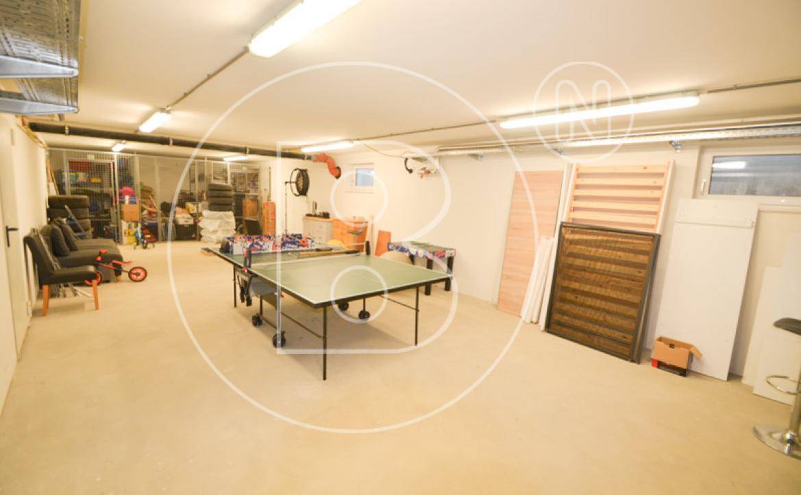 Geräumiger Kellerraum mit Pingpong-Tisch, Stauraum und funktionaler Beleuchtung.