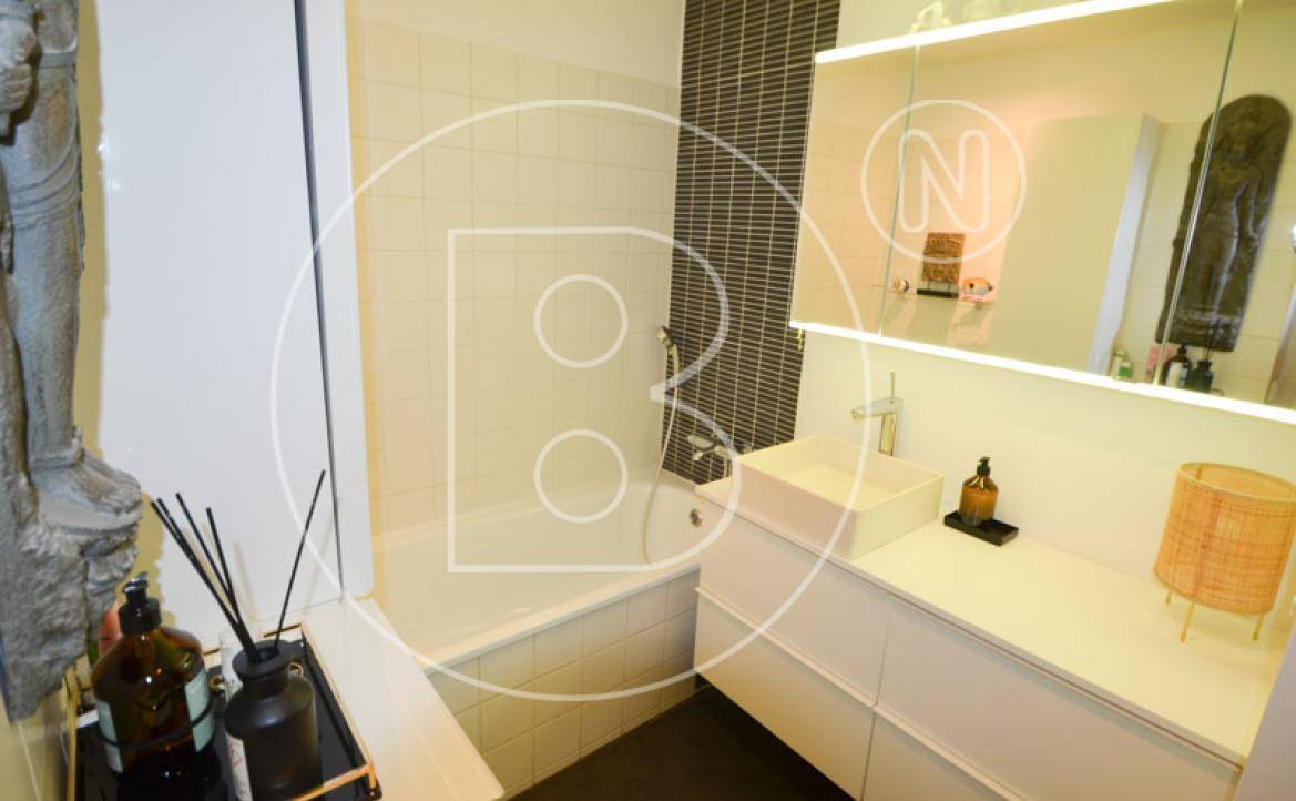 Modernes Badezimmer mit Badewanne, stilvollem Waschbecken und Spiegelschrank.