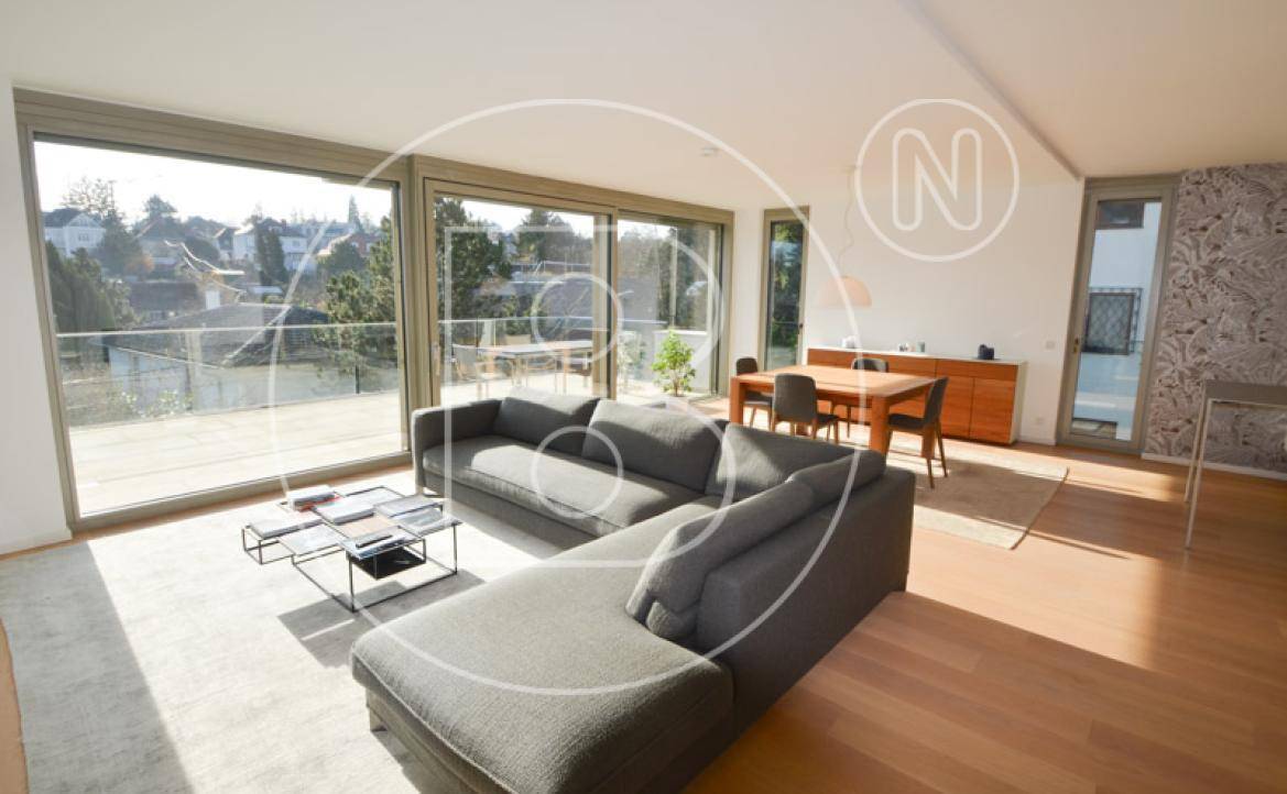 Lichtdurchfluteter Wohn- und Essbereich mit Holzboden und Zugang zur großen Terrasse.