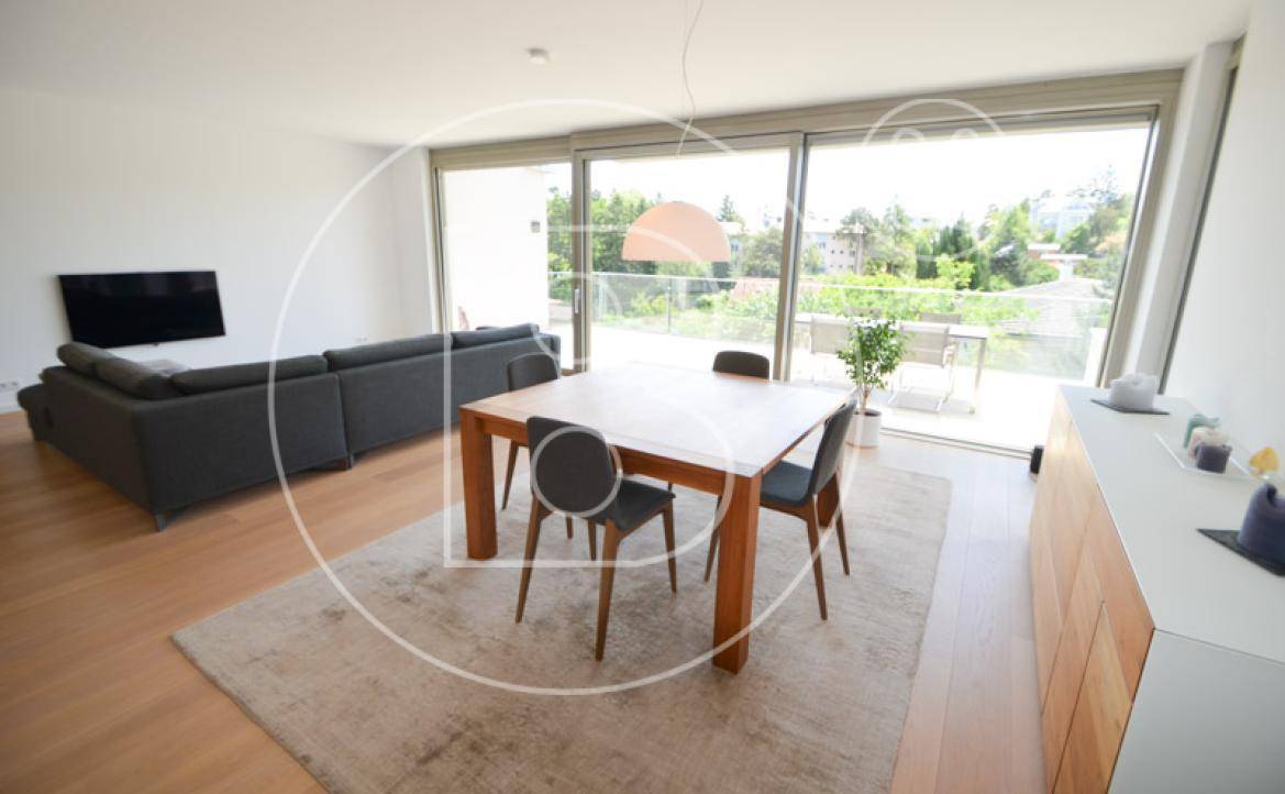 Heller Essbereich mit Holztisch und Stühlen, angrenzend an den Wohnbereich mit Terrassenzugang.