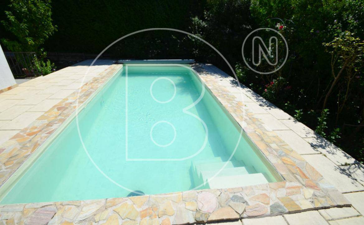 Nahaufnahme des Pools mit hellblauer Wasseroberfläche und dekorativer Steinumrandung.