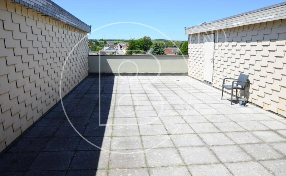Große, gepflasterte Dachterrasse mit weitem Blick über die Landschaft.