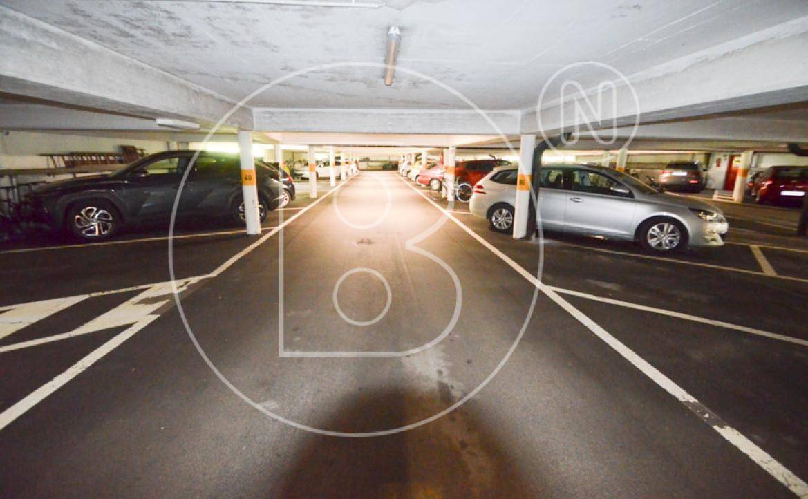 Tiefgarage mit zahlreichen Parkplätzen und Betonstützen für die Gebäudestruktur.