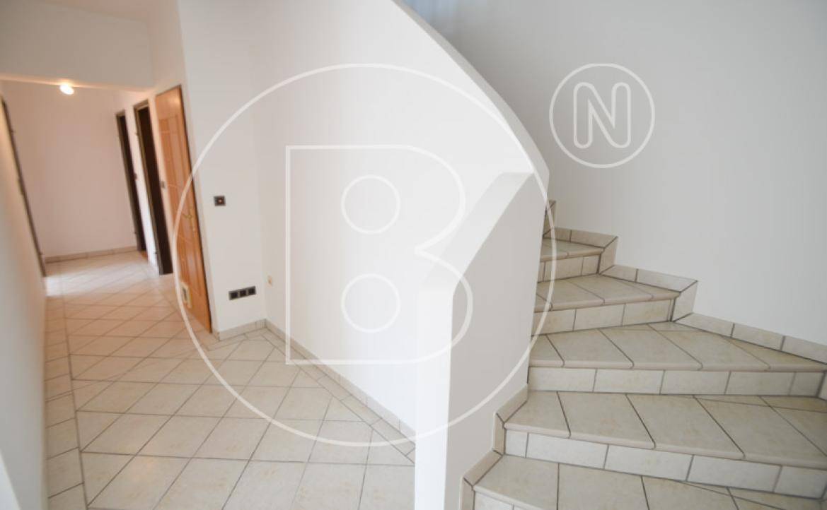 Heller Flur mit Fliesenboden und Treppe, die in die obere Etage führt.