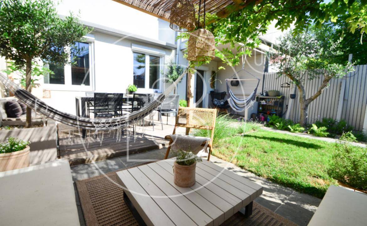 Entspannende Terrasse mit Hängematten, Essbereich und üppiger Bepflanzung.