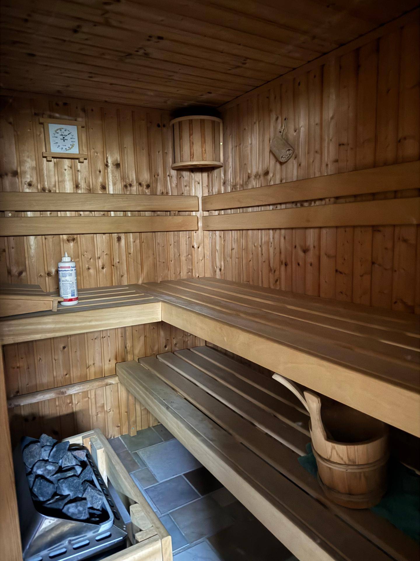Gemütliche Sauna mit Holzverkleidung und traditionellem Saunaofen.