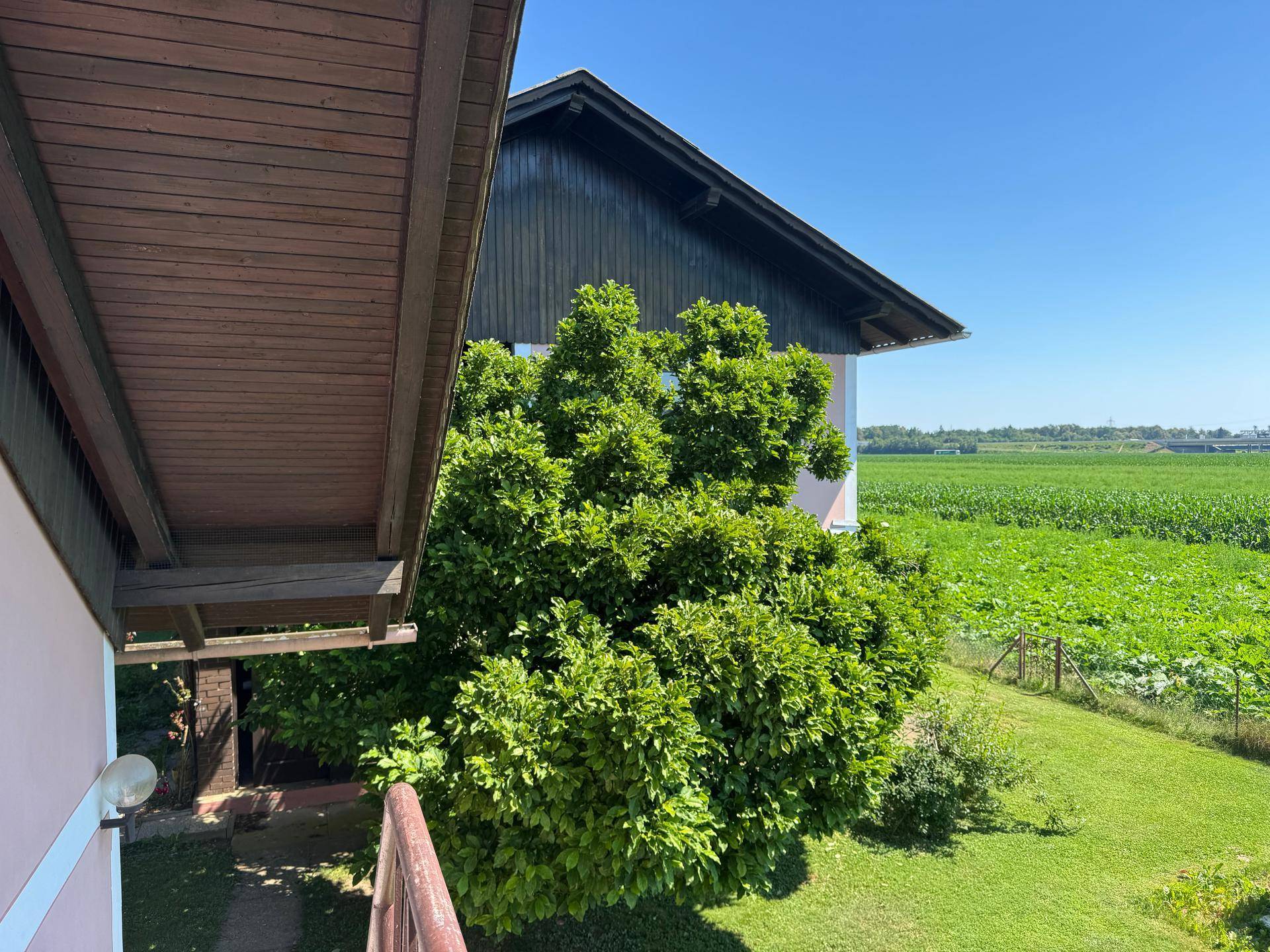 Weitläufiger Blick von der Loggia auf die umliegende Landschaft und Felder.