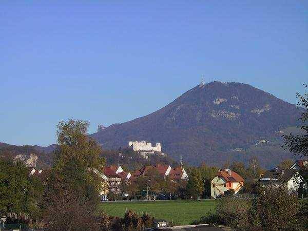 Geräumiges Büro im Dachgeschoss mit sichtbaren Holzbalken, großen Fenstern und Terrakottafliesen.