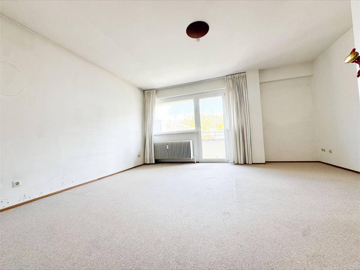 Helles Schlafzimmer mit Teppichboden und Zugang zu einem Balkon, ideal für entspannte Stunden.