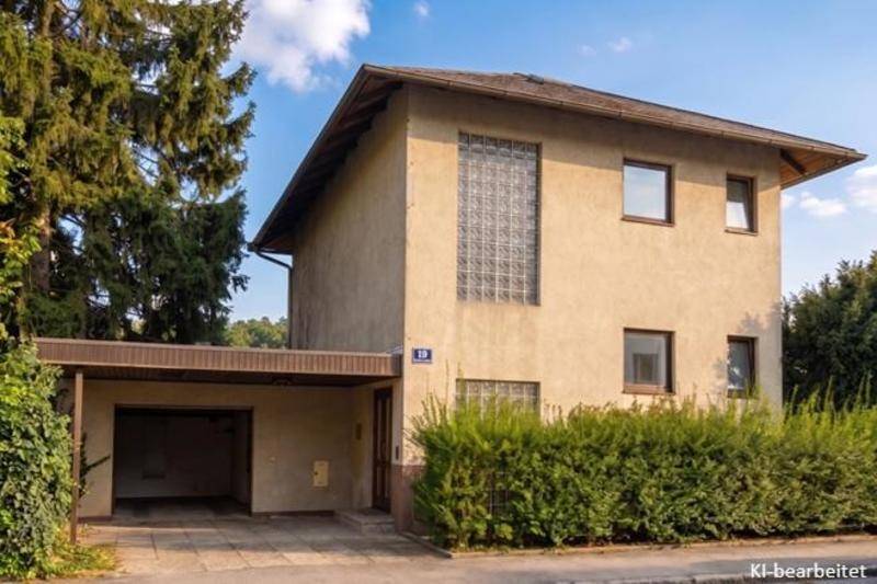 Vorderansicht des Hauses mit Carport, Hecke und Glasbausteinfenster.