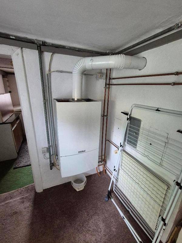 Hauswirtschaftsraum mit Heizungsanlage und Wäscheständer.