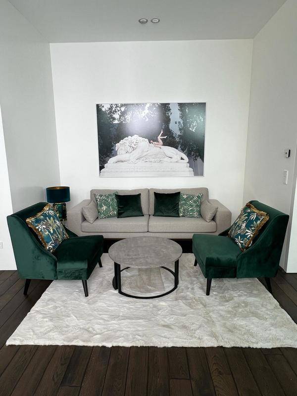 Elegantes Wohnzimmer mit dunklem Holzboden, bequemen Sofas und einem großen Kunstwerk an der weißen Wand.