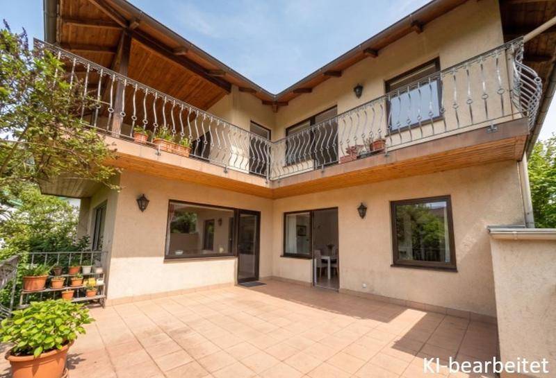 Große, geflieste Terrasse im Erdgeschoss mit Zugang zu den Innenräumen und Balkonen darüber.