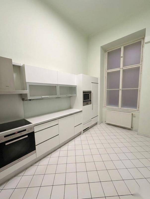 Moderne Einbauküche in Weiß mit integrierten Geräten und Fliesenboden.