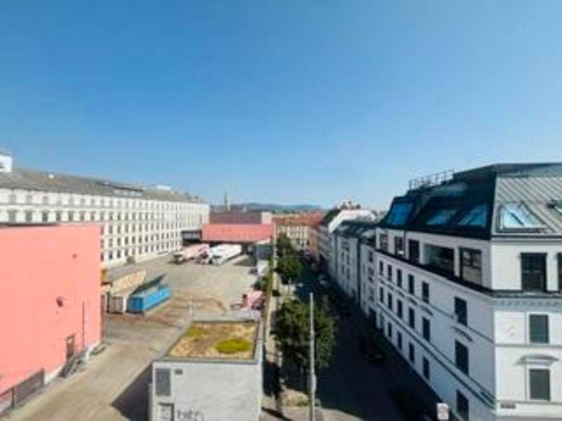 Weitläufiger Blick über die Stadt mit Gebäuden, Straßen und blauem Himmel.