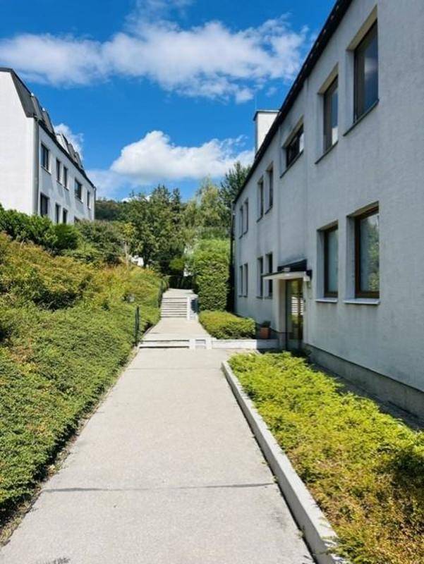 Außenansicht von Wohngebäuden mit einem gepflegten Fußweg und Grünflächen.