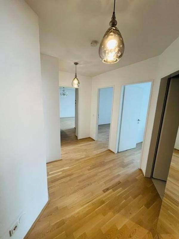 Heller Flur mit Parkettboden und Zugang zu verschiedenen Zimmern der Wohnung.