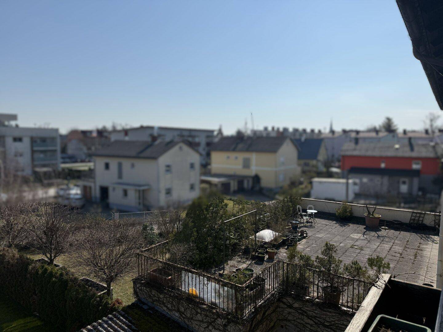 Weitläufiger Blick über die Dächer der Nachbarschaft und umliegende Gebäude an einem sonnigen Tag.