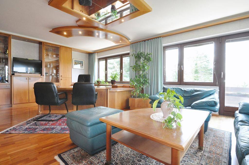 Elegantes Büro mit Parkettboden, dekorativer Deckenbeleuchtung und großen Fenstern mit Ausblick.