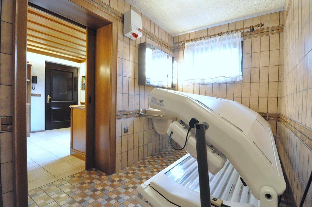 Gefliester Raum mit Solarium und Fenster, möglicherweise als Hobby- oder Wellnessbereich genutzt.