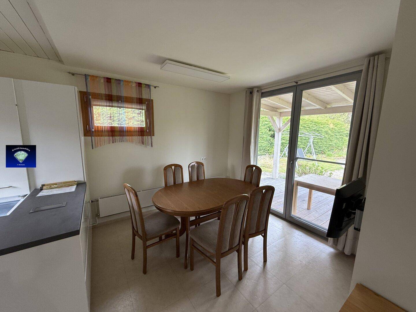 Gemütlicher Essbereich mit Holztisch und Stühlen, direktem Zugang zur Außenterrasse.