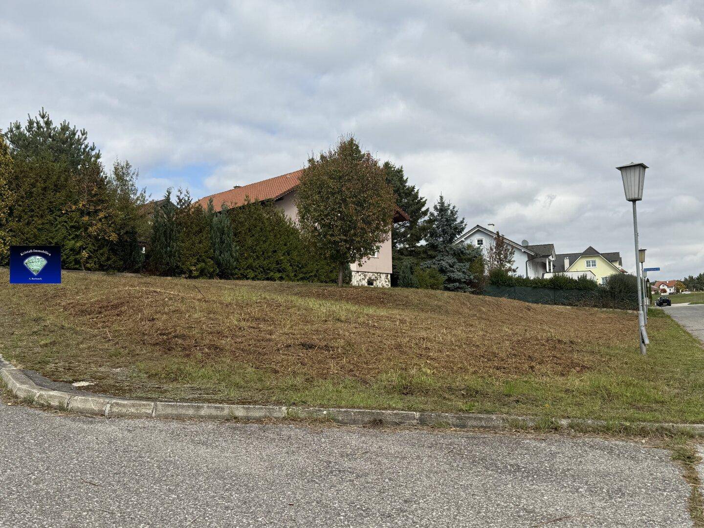 Weitläufiges Grundstück an einer ruhigen Straße, umgeben von Wohnbebauung und viel Grün.