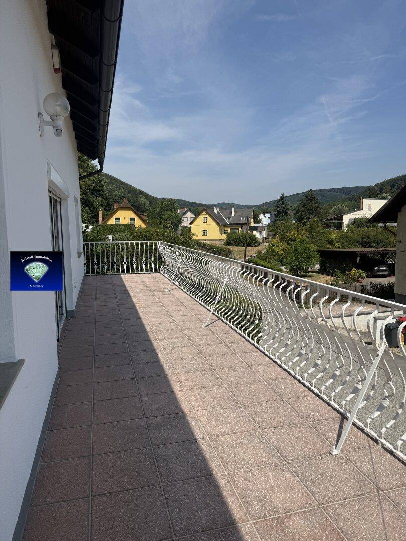Geräumiger Balkon mit Fliesenboden und schmiedeeisernem Geländer, bietet Weitblick.