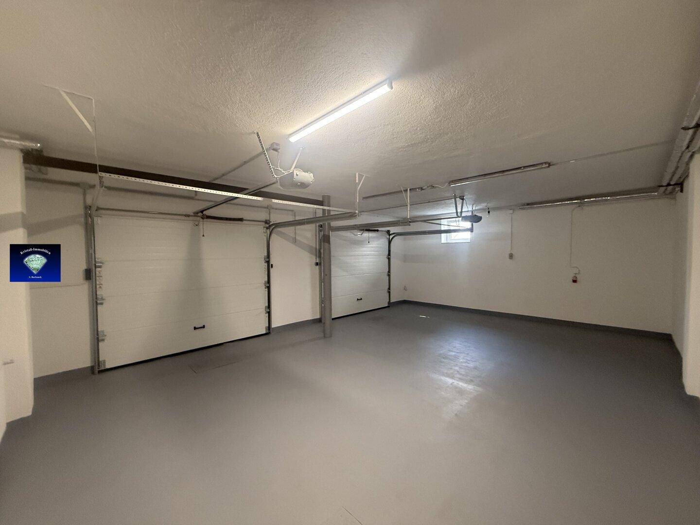 Geräumige Doppelgarage mit zwei Sektionaltoren und ausreichend Platz für Fahrzeuge.