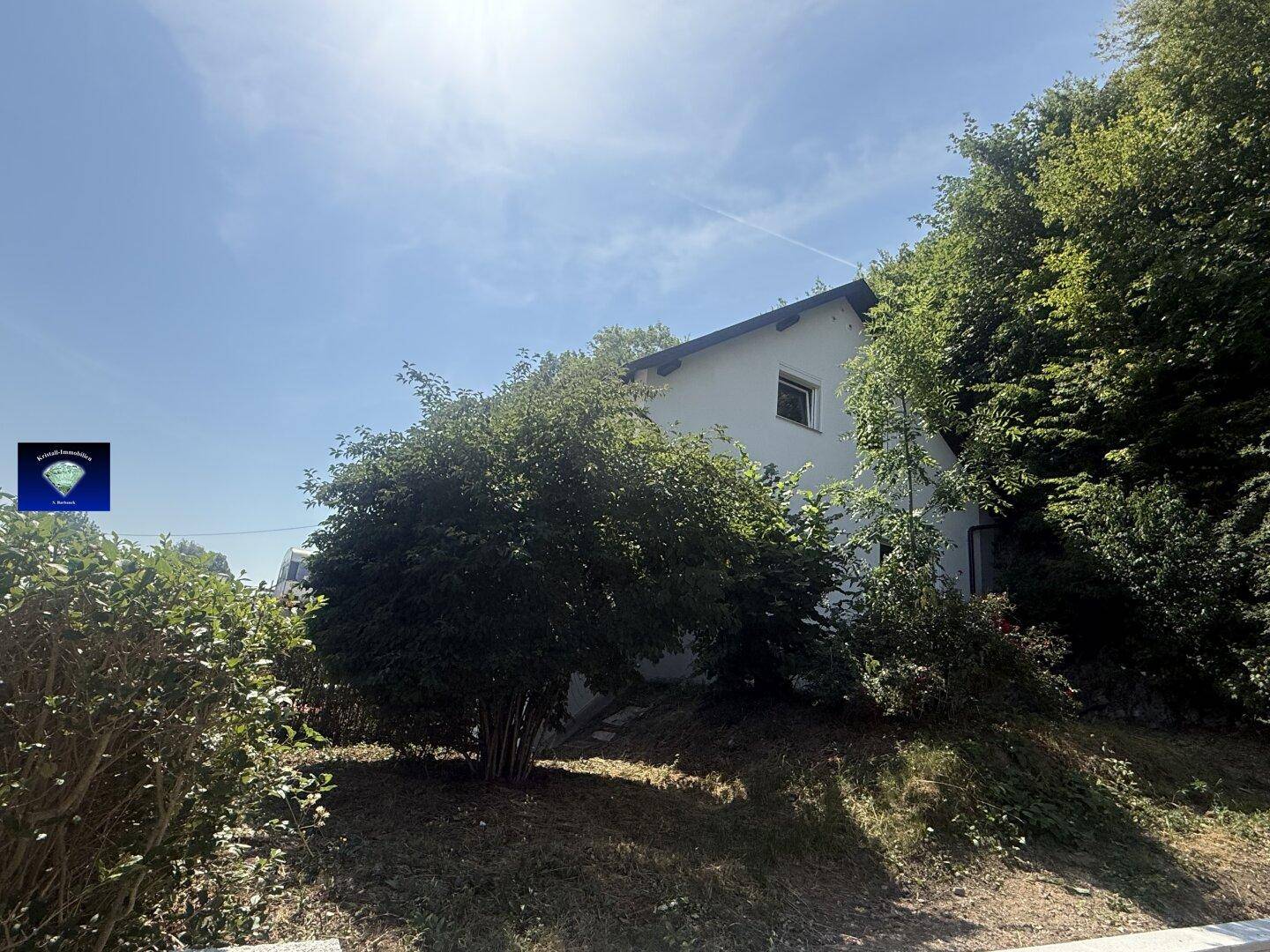 Das Haus ist von dichtem Grün umgeben, was eine private Atmosphäre schafft.