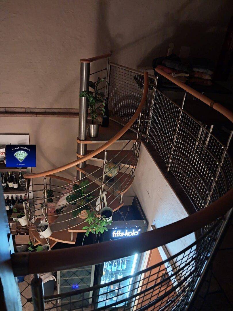 Moderne Wendeltreppe aus Metall und Holz, die verschiedene Ebenen stilvoll verbindet.