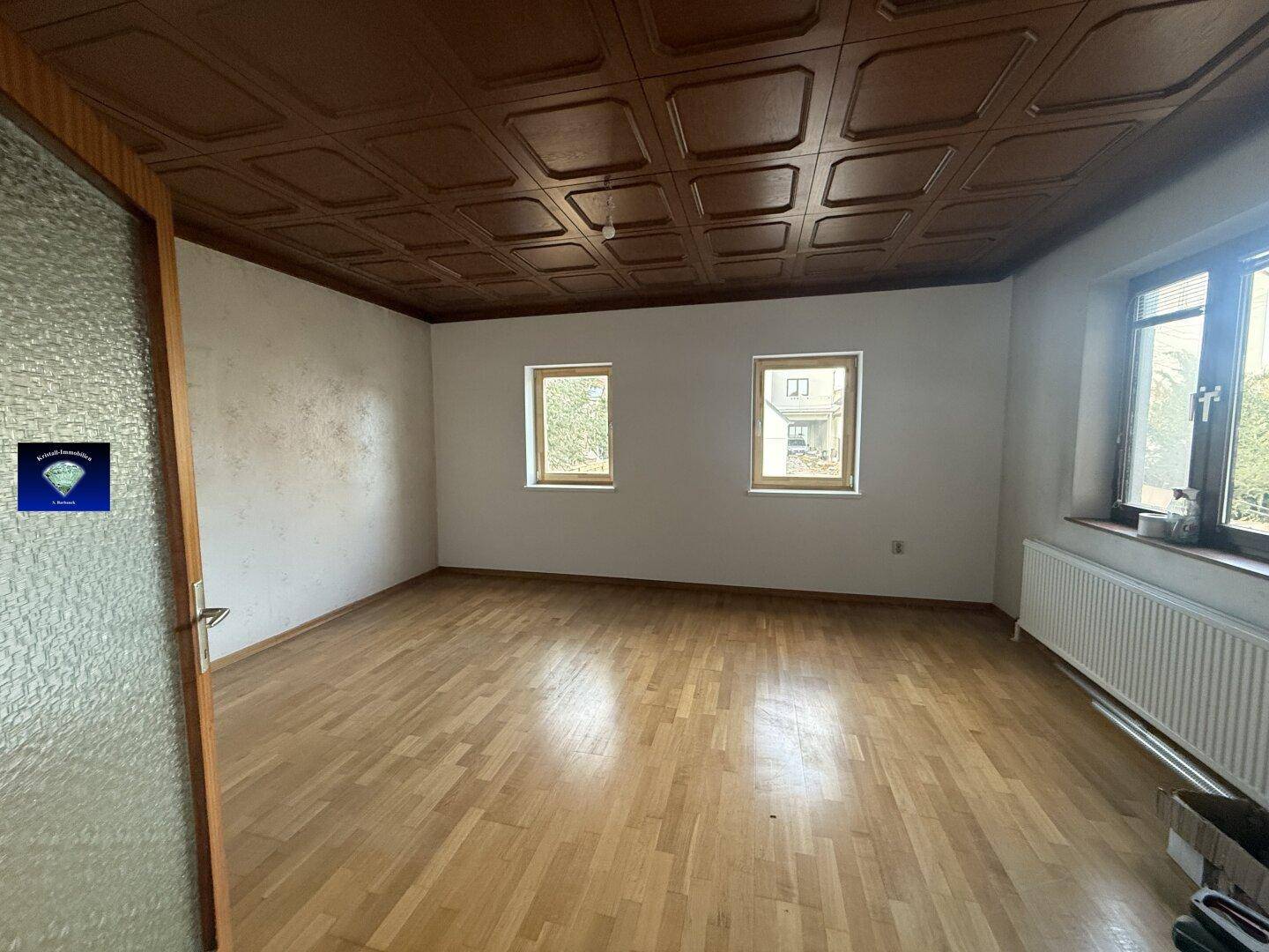 Geräumiges Zimmer mit Holzparkettboden und einer Holzdecke, bereit zur individuellen Gestaltung.