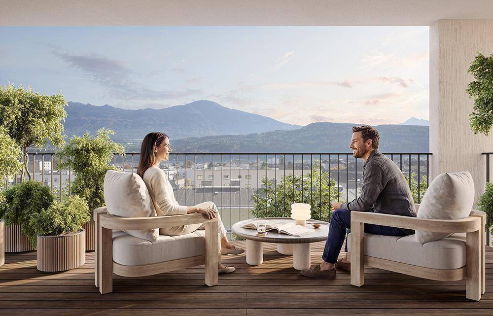 Gemütlicher Balkon mit Holzboden und modernen Möbeln, bietet einen weiten Bergblick.