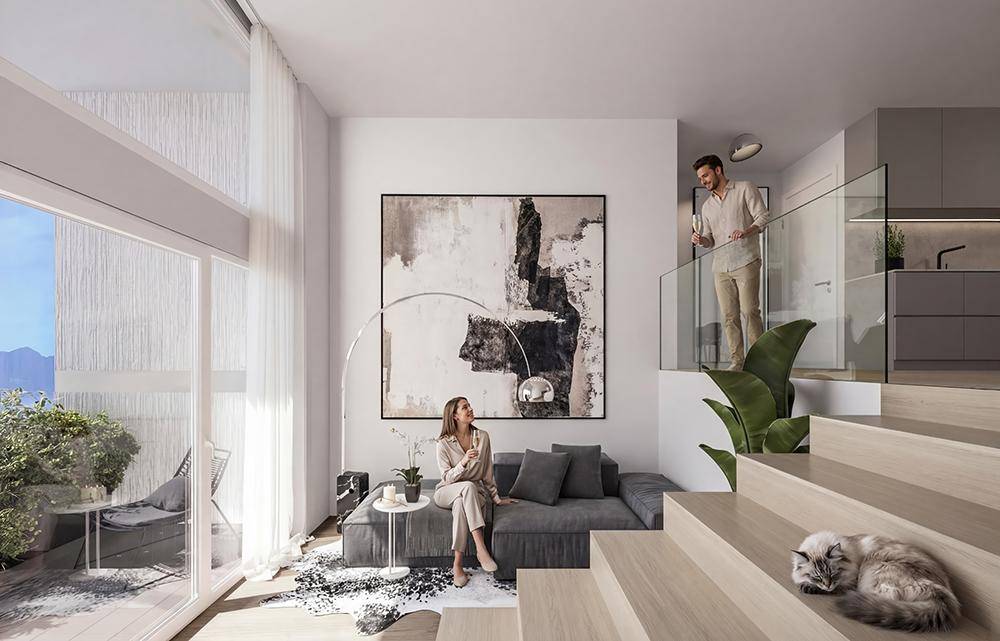 Modernes Wohnzimmer mit hohen Decken, Holztreppe und Zugang zu einem Balkon.
