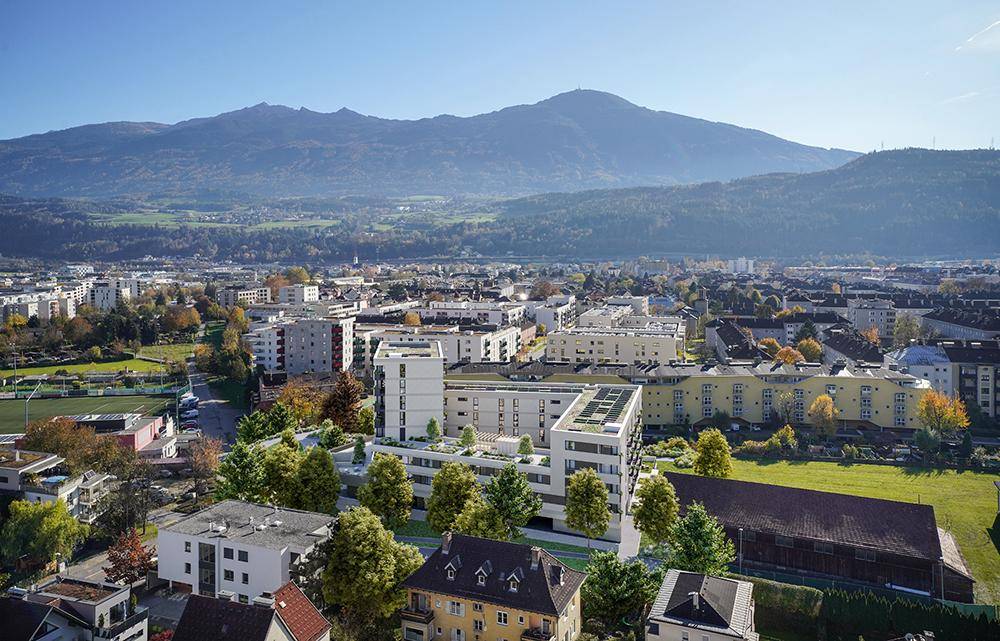 Luftaufnahme der Wohnanlage in städtischer Umgebung mit Blick auf die umliegenden Berge.