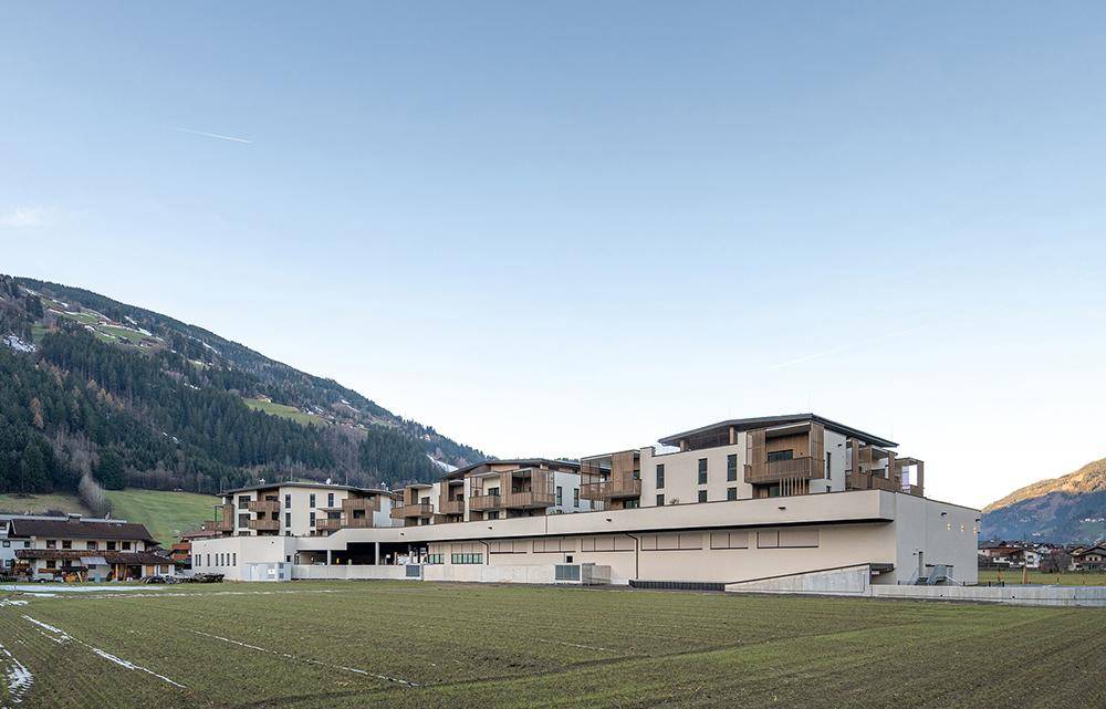 Moderne Wohnanlage mit Terrassen und Balkonen, eingebettet in eine ländliche Umgebung.