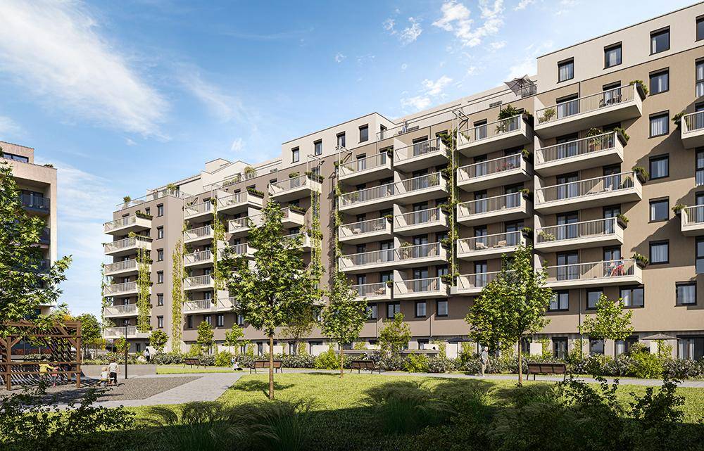 Moderne Wohnanlage mit vielen Balkonen und einem gepflegten Innenhof unter blauem Himmel.