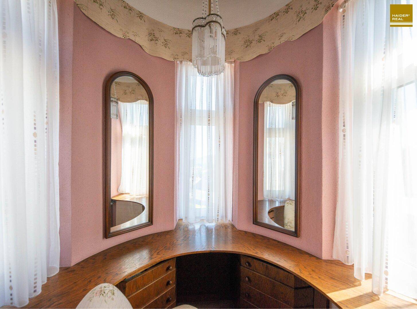 Einzigartiger Ankleidebereich im Turmzimmer mit geschwungenem Waschtisch und großen Spiegeln.