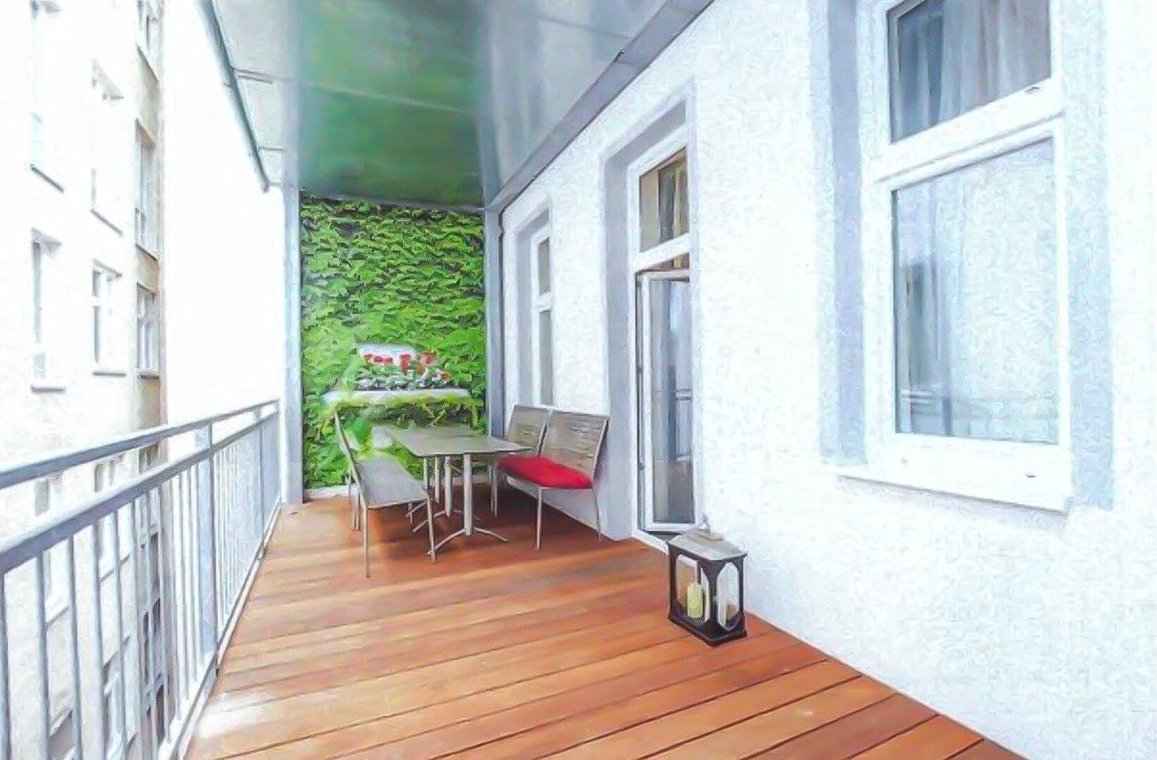 Gemütlicher Balkon mit Holzfußboden, einer grünen Wanddekoration und Sitzgelegenheiten.
